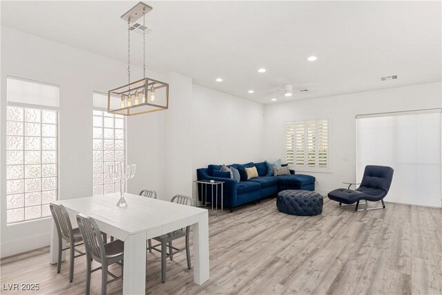 dining area featuring visible vents, recessed lighting, a notable chandelier, and light wood-style flooring