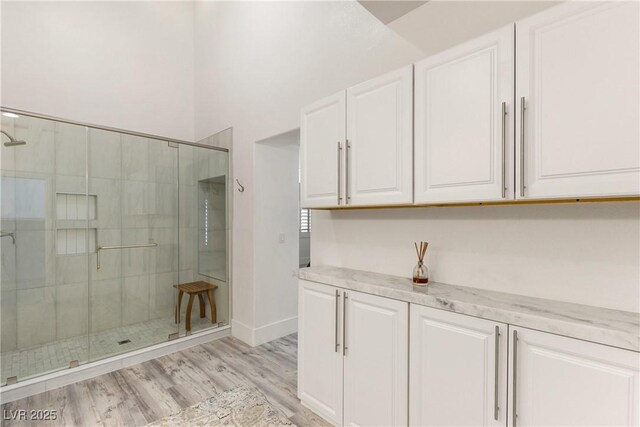 interior space with wood finished floors and a stall shower