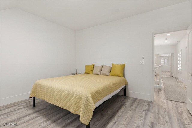 bedroom with vaulted ceiling, baseboards, light wood-style floors, and recessed lighting