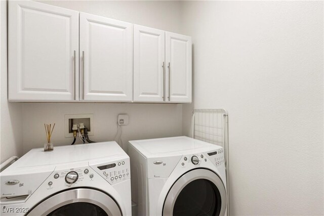 washroom with washer and clothes dryer and cabinet space