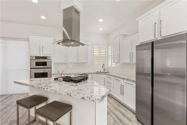 kitchen featuring range hood, a sink, white cabinets, and stainless steel appliances