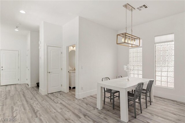 dining area featuring baseboards, visible vents, light wood-type flooring, and plenty of natural light