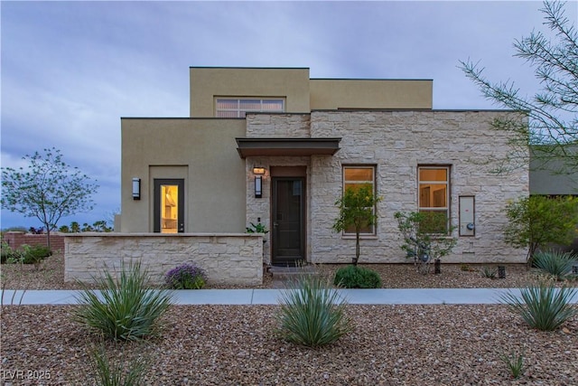 contemporary house featuring stone siding and stucco siding