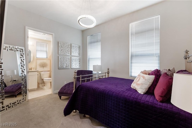 bedroom with light carpet and ensuite bathroom