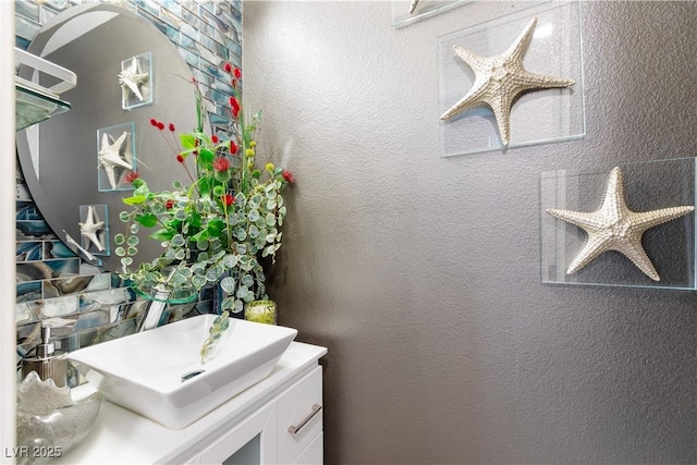 bathroom with a textured wall and vanity