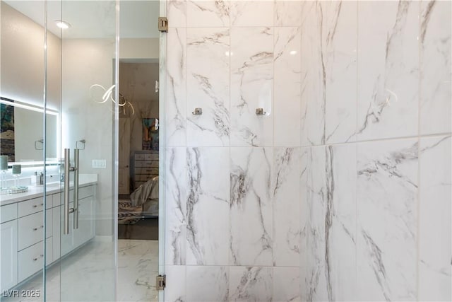 ensuite bathroom featuring marble finish floor, vanity, and ensuite bathroom
