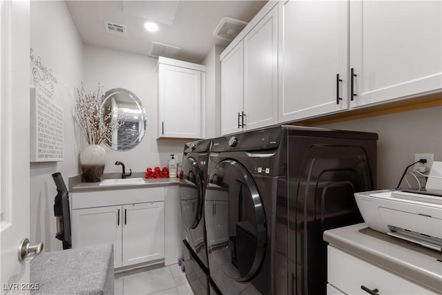 laundry room featuring visible vents, light tile patterned floors, a sink, independent washer and dryer, and cabinet space