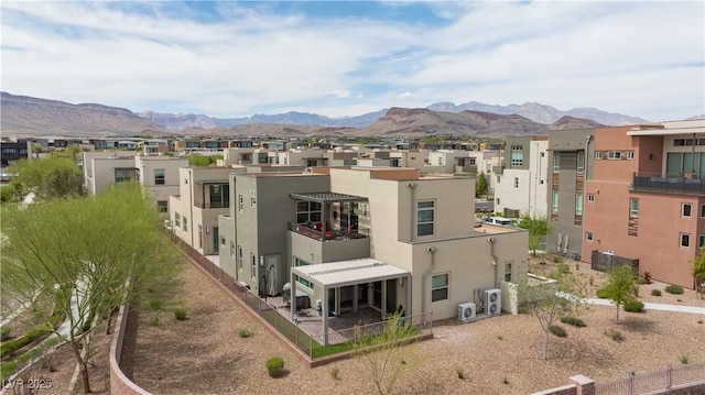 rear view of property featuring a residential view, stucco siding, and a mountain view