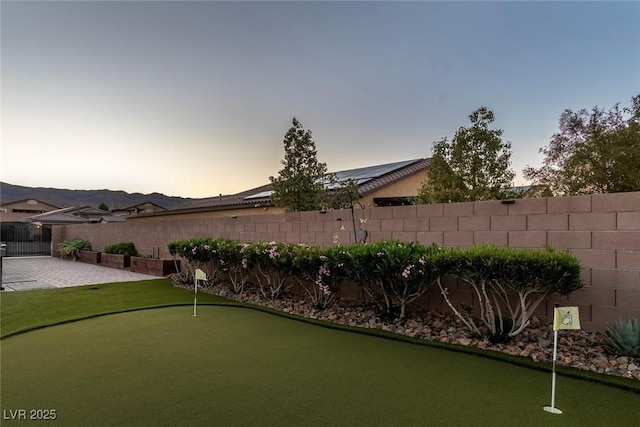 5852 Ireland Ridge Ct, Las Vegas, NV 89149 - fenced backyard featuring an area to practice putting and a patio area