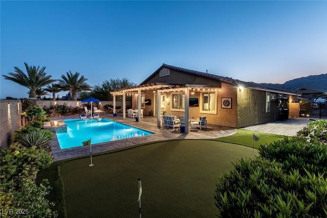5852 Ireland Ridge Ct, Las Vegas, NV 89149 - back of property with a putting green, a fenced backyard, a patio area, and a pergola