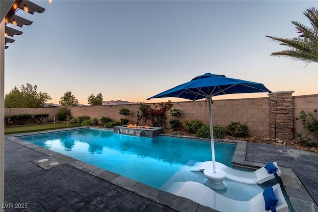 5852 Ireland Ridge Ct, Las Vegas, NV 89149 - pool at dusk featuring a fenced backyard and a patio area