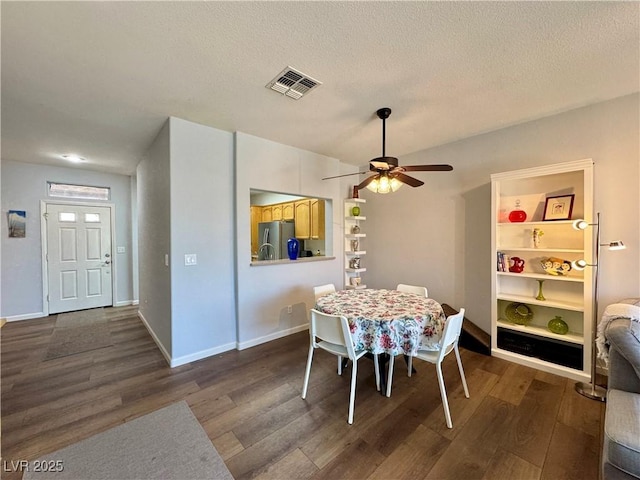 dining room featuring dark wood-style floors, baseboards, a ceiling fan, and visible vents