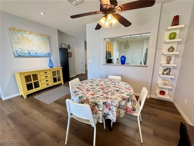 dining area with baseboards, a ceiling fan, wood finished floors, and visible vents