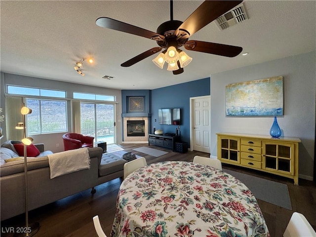 bedroom with baseboards, wood finished floors, visible vents, and a textured ceiling
