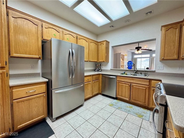 kitchen with stainless steel appliances, visible vents, a sink, and light tile patterned flooring