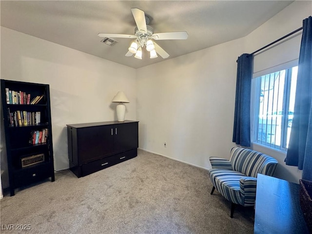living area featuring a ceiling fan, visible vents, and carpet