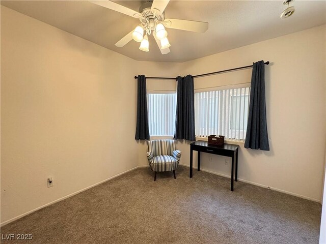 living area with a ceiling fan, baseboards, and carpet