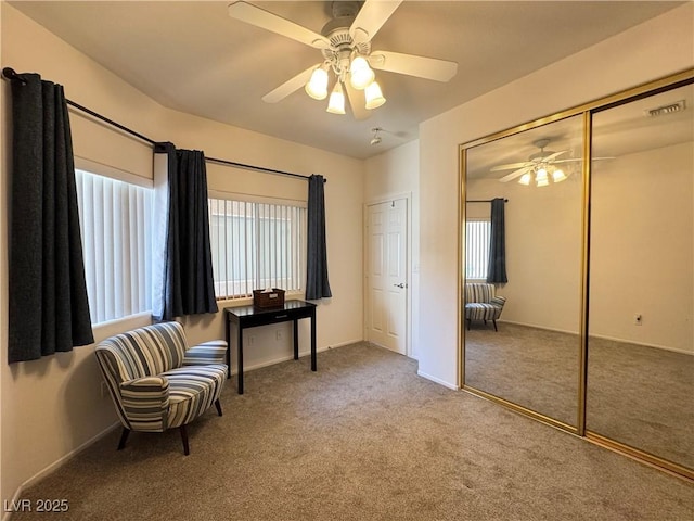 living area with baseboards, a ceiling fan, carpet flooring, and visible vents