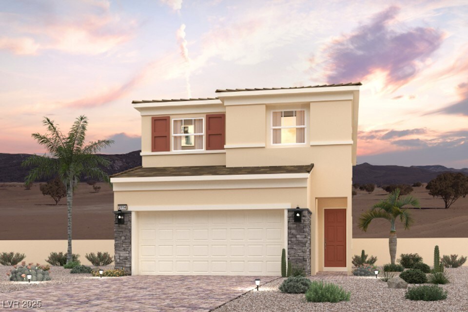 view of front of house with stucco siding, an attached garage, decorative driveway, and stone siding