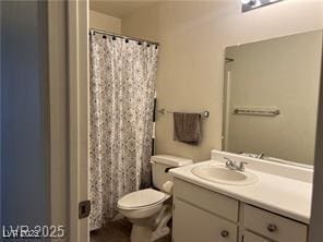 bathroom featuring toilet, vanity, and a shower with shower curtain