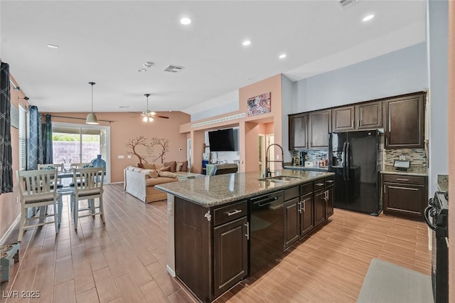 2104 Leatherbridge Ct, North Las Vegas, NV 89081 - kitchen featuring black appliances, a sink, a ceiling fan, an island with sink, and backsplash