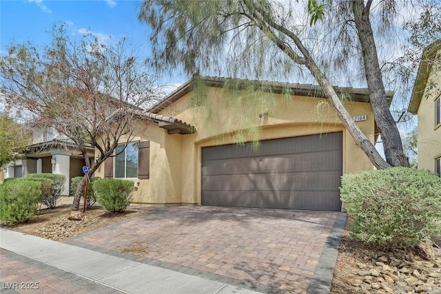 2104 Leatherbridge Ct, North Las Vegas, NV 89081 - view of front of house featuring stucco siding, decorative driveway, an attached garage, and a tiled roof