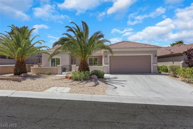 view of front facade featuring an attached garage, stucco siding, a tiled roof, fence private yard, and driveway