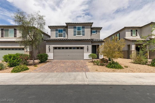 1004 Huckburn Ave, Henderson, NV 89015 - view of front of house featuring a garage, a tiled roof, stucco siding, and decorative driveway