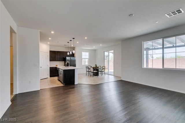 1004 Huckburn Ave, Henderson, NV 89015 - unfurnished living room with recessed lighting, visible vents, a sink, light wood-type flooring, and baseboards