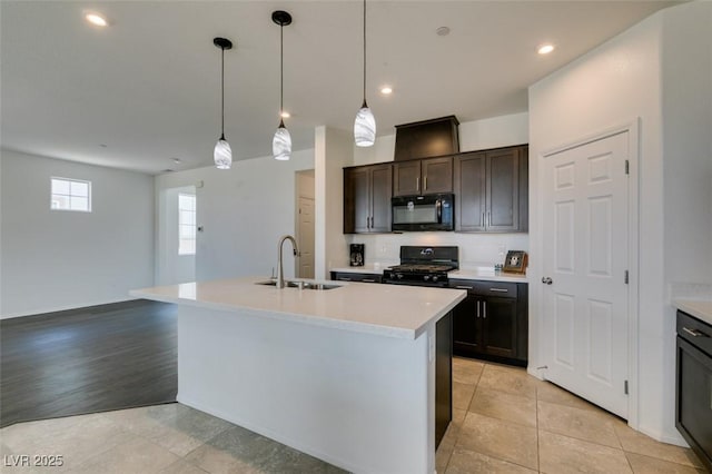 1004 Huckburn Ave, Henderson, NV 89015 - kitchen with dark brown cabinets, a sink, black appliances, a kitchen island with sink, and light countertops