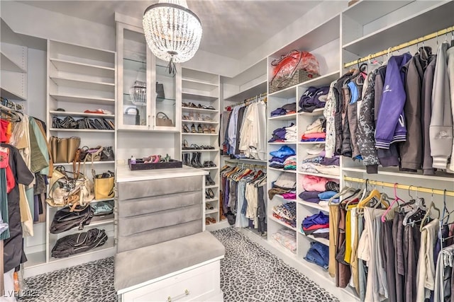 walk in closet with an inviting chandelier