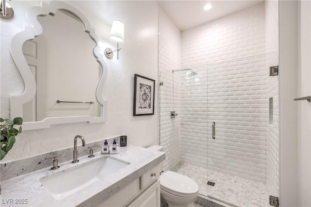 bathroom with recessed lighting, vanity, toilet, and a stall shower