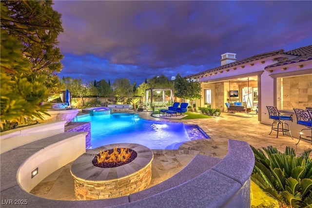 view of swimming pool featuring a patio area, a fire pit, and a pool with connected hot tub