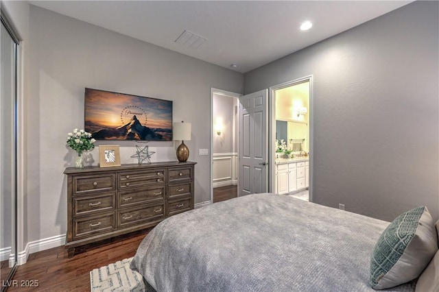 bedroom with dark wood-style floors, ensuite bathroom, baseboards, visible vents, and recessed lighting