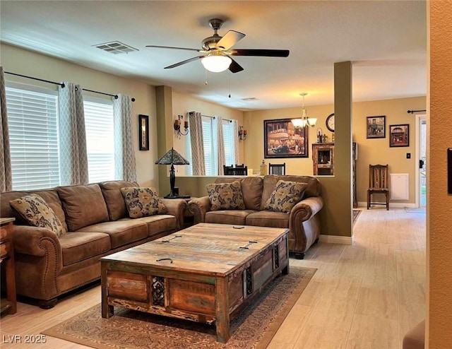 1121 Majestic Canyon St, Henderson, NV 89052 - living room with light wood-style flooring, visible vents, and ceiling fan with notable chandelier