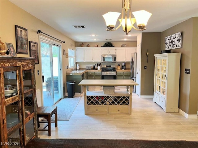 1121 Majestic Canyon St, Henderson, NV 89052 - kitchen with baseboards, visible vents, a sink, a chandelier, and appliances with stainless steel finishes