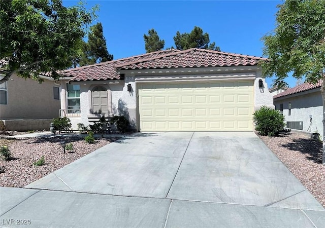 1121 Majestic Canyon St, Henderson, NV 89052 - mediterranean / spanish house with an attached garage, central AC, stucco siding, a tile roof, and driveway