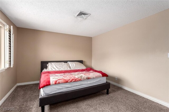 carpeted bedroom featuring a textured ceiling, visible vents, and baseboards