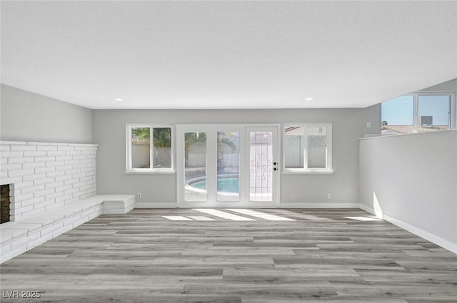 3791 El Camino Rd, Las Vegas, NV 89103 - unfurnished living room featuring a fireplace, wood finished floors, and recessed lighting