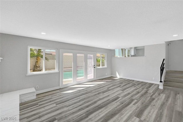 3791 El Camino Rd, Las Vegas, NV 89103 - unfurnished living room with wood finished floors, french doors, recessed lighting, and a textured ceiling