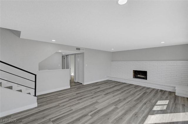 3791 El Camino Rd, Las Vegas, NV 89103 - unfurnished living room featuring wood finished floors, a fireplace, stairs, and recessed lighting
