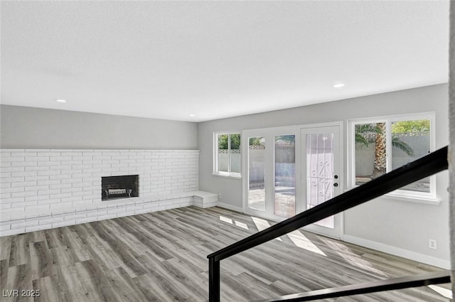 3791 El Camino Rd, Las Vegas, NV 89103 - unfurnished living room with wood finished floors, a brick fireplace, and recessed lighting