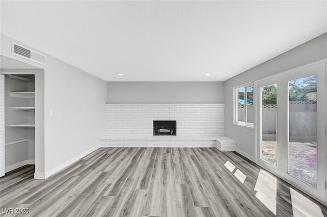 3791 El Camino Rd, Las Vegas, NV 89103 - unfurnished living room featuring wood finished floors, a brick fireplace, and recessed lighting