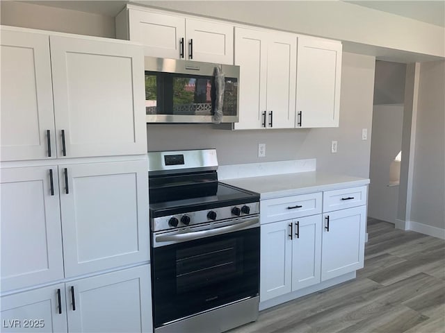 3791 El Camino Rd, Las Vegas, NV 89103 - kitchen featuring appliances with stainless steel finishes, light countertops, light wood-type flooring, and white cabinets