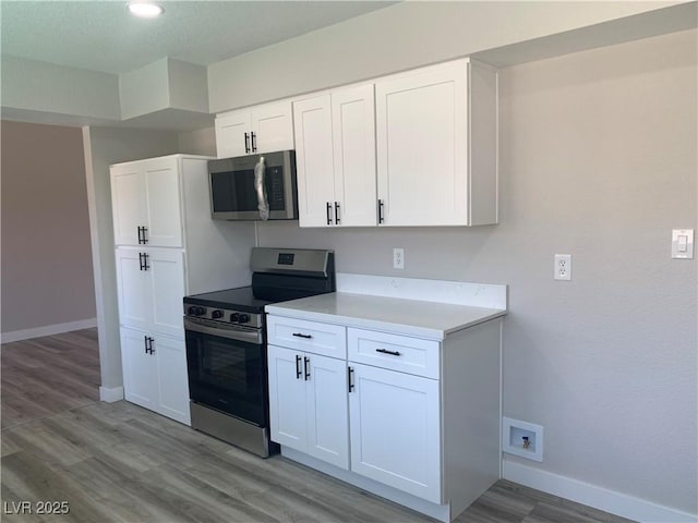 3791 El Camino Rd, Las Vegas, NV 89103 - kitchen with appliances with stainless steel finishes, light wood finished floors, light countertops, and white cabinetry