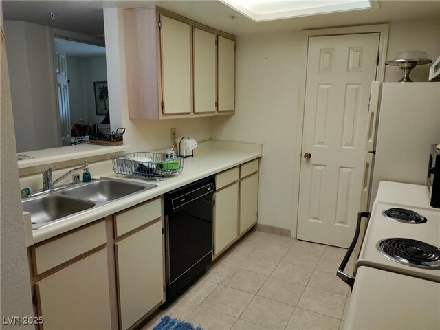 kitchen featuring light countertops, a sink, light tile patterned flooring, white appliances, and cream cabinets