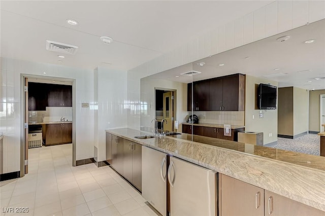 kitchen with baseboards, backsplash, refrigerator, and visible vents