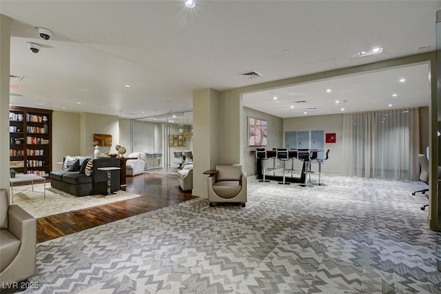 living room with recessed lighting, wood finished floors, and visible vents