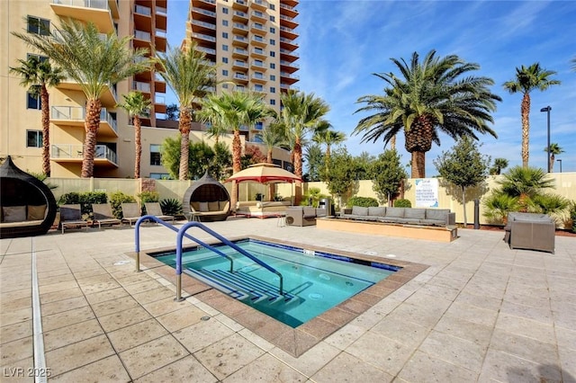 view of pool featuring a hot tub, a patio, fence, and an outdoor hangout area