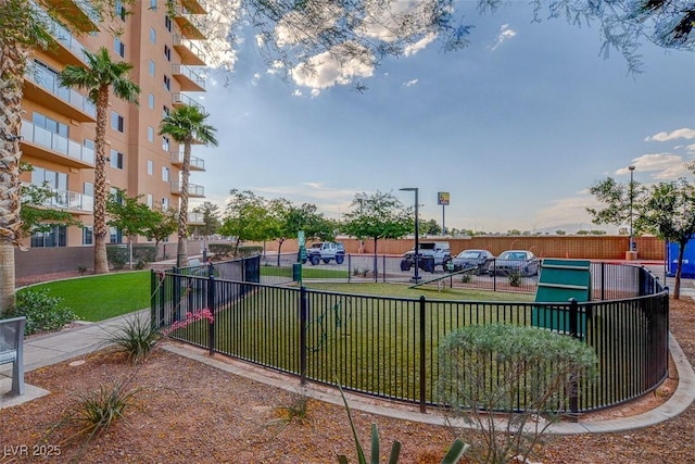 view of property's community with a lawn and fence